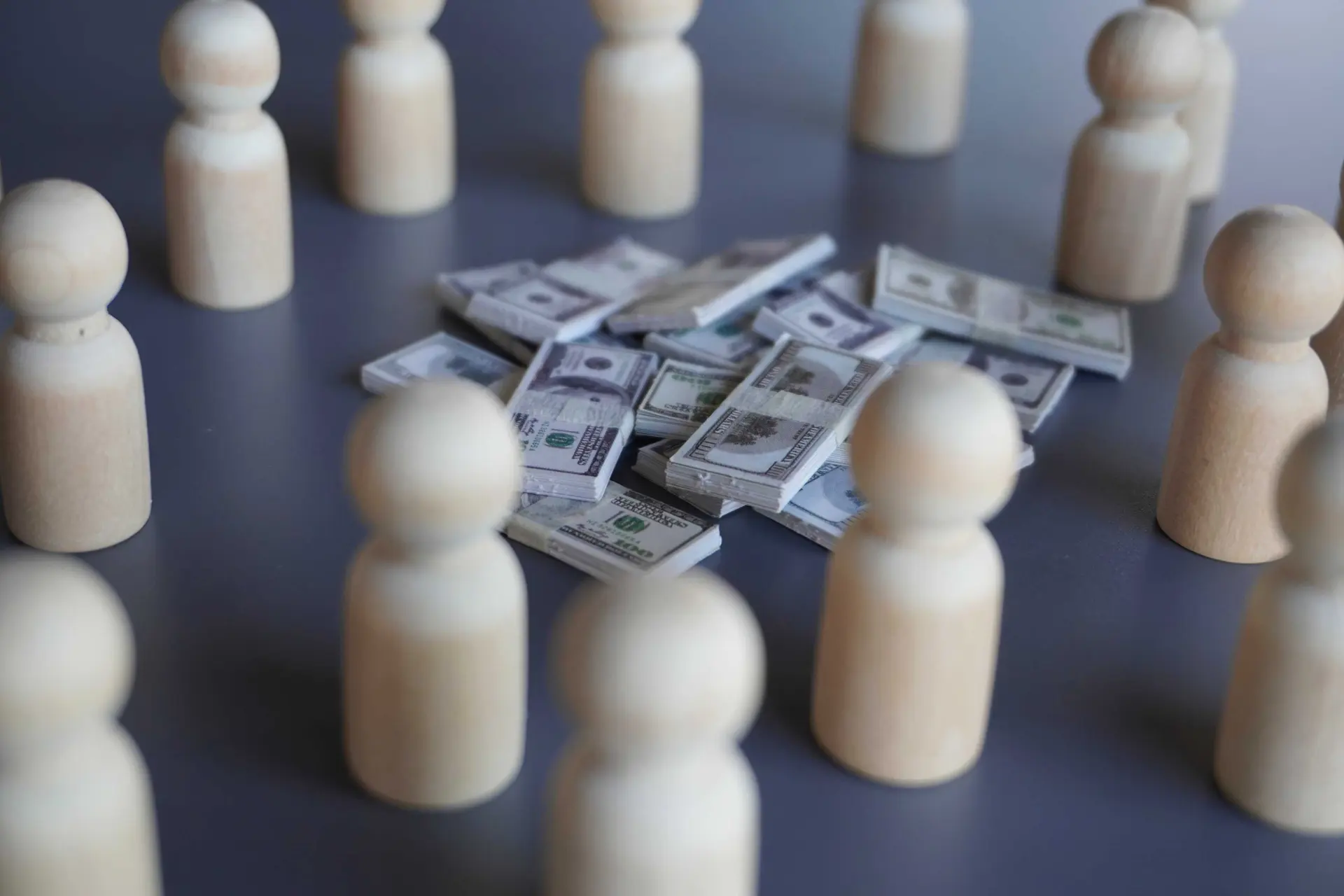 Wooden figures surrounding stacks of money, illustrating the hidden financial impact of poor Microsoft Dynamics 365 data quality with Dynamics Monk.